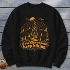 Black sweatshirt with orange graphic of mountains, lantern, and text "If you hear whistlin', keep hiking."
