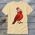 Beige short-sleeve t-shirt featuring a graphic of a red cardinal wearing a winter hat with a pom-pom.