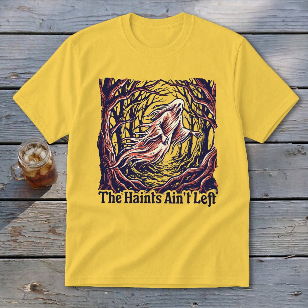 Yellow t-shirt with a ghost in a spooky forest and text that reads "The Haints Ain't Left."