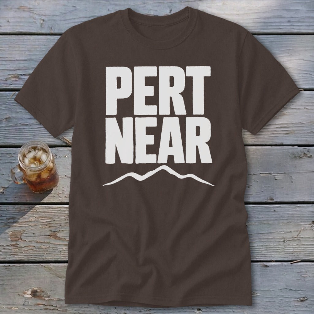 A dark brown t-shirt featuring the white text PERT NEAR and a mountain range graphic underneath.