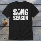 A black t-shirt printed with the text SANG SEASON and a silhouette of a person digging with a shovel.