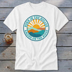 A white short-sleeved t-shirt featuring a retro mountain and sunrise graphic with the text Born in the Holler Raised on the Ridge.