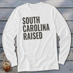 White long sleeve t-shirt with "SOUTH CAROLINA RAISED" in dark gray block letters.