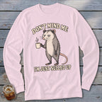 Pink long sleeve shirt with a grumpy opossum holding a coffee cup and text that reads "Don't mind me I'm just sulled up."