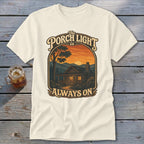 Graphic t-shirt with text: "The Porch Light is Always On" and a cabin scene.