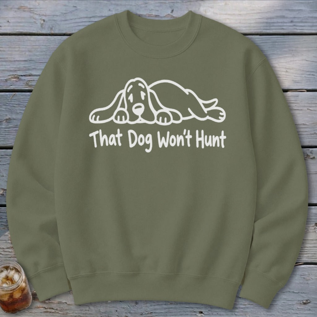 Olive green crewneck sweatshirt featuring a white line drawing of a sad hound dog and the text That Dog Won't Hunt.