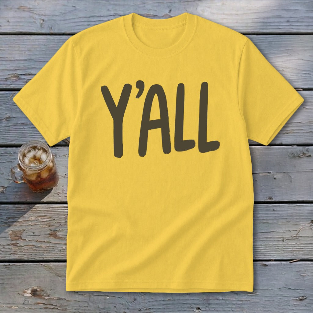 Yellow t-shirt with dark brown text reading "Y'ALL" next to a glass of iced tea.