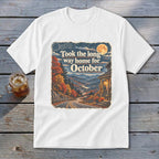 White t-shirt graphic with "Took the long way home for October" text and autumn mountain scene.