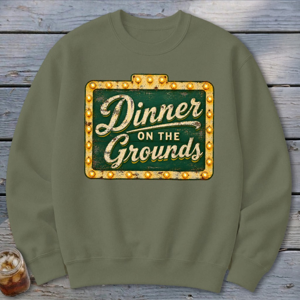 Olive green crewneck sweatshirt featuring a distressed marquee sign graphic that reads Dinner on the Grounds.