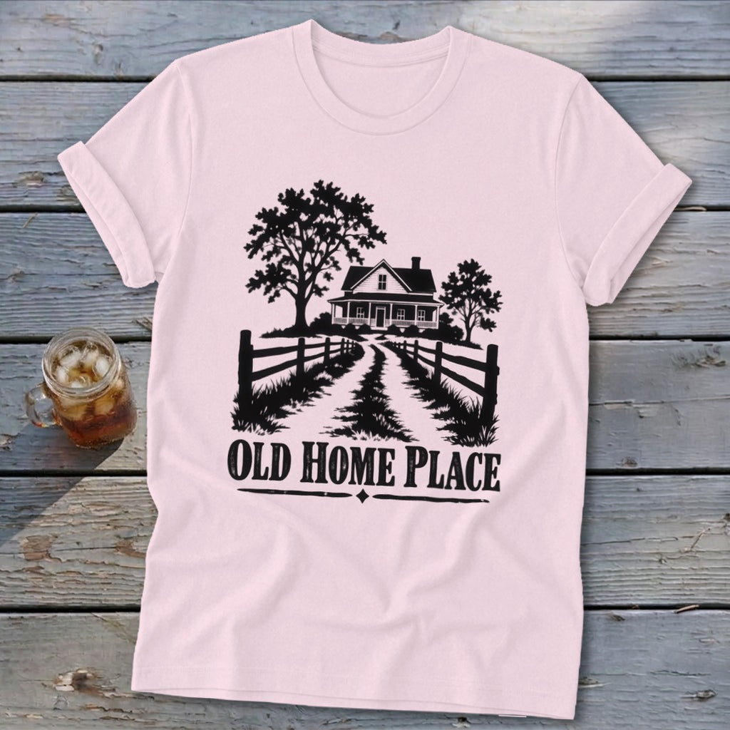 Pink t-shirt with black graphic of a farmhouse, trees, fence, and text "OLD HOME PLACE".