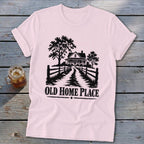Pink t-shirt with black graphic of a farmhouse, trees, fence, and text "OLD HOME PLACE".