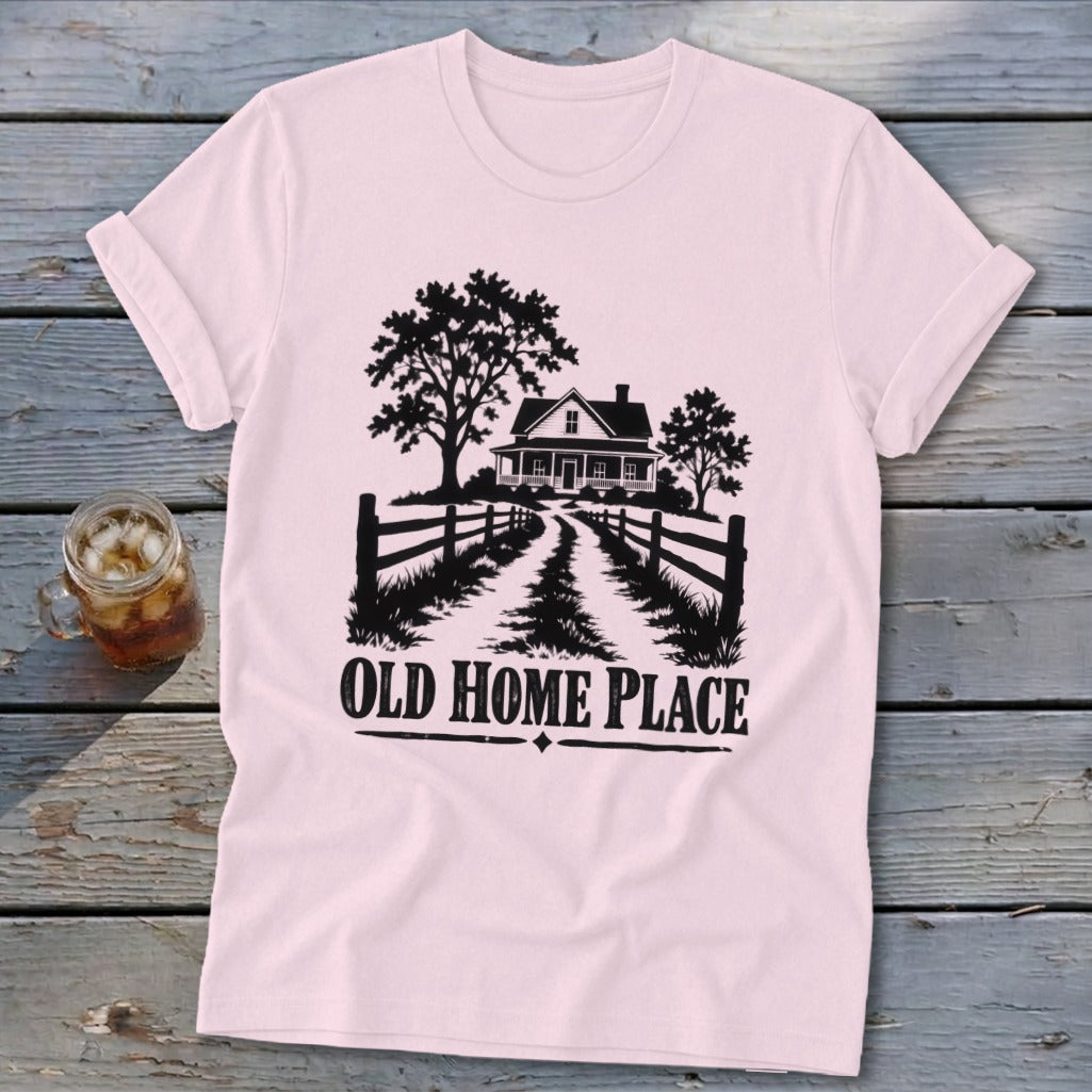 Pink t-shirt with black graphic of a farmhouse, trees, fence, and text "OLD HOME PLACE".