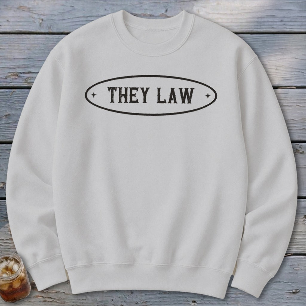 White crewneck sweatshirt with "THEY LAW" text in an oval.
