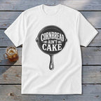 White t-shirt with a cast iron skillet graphic and the text "Cornbread ain't cake".