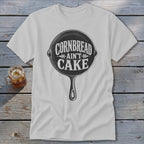 White t-shirt with "Cornbread Ain't Cake" text inside a cast iron skillet graphic.
