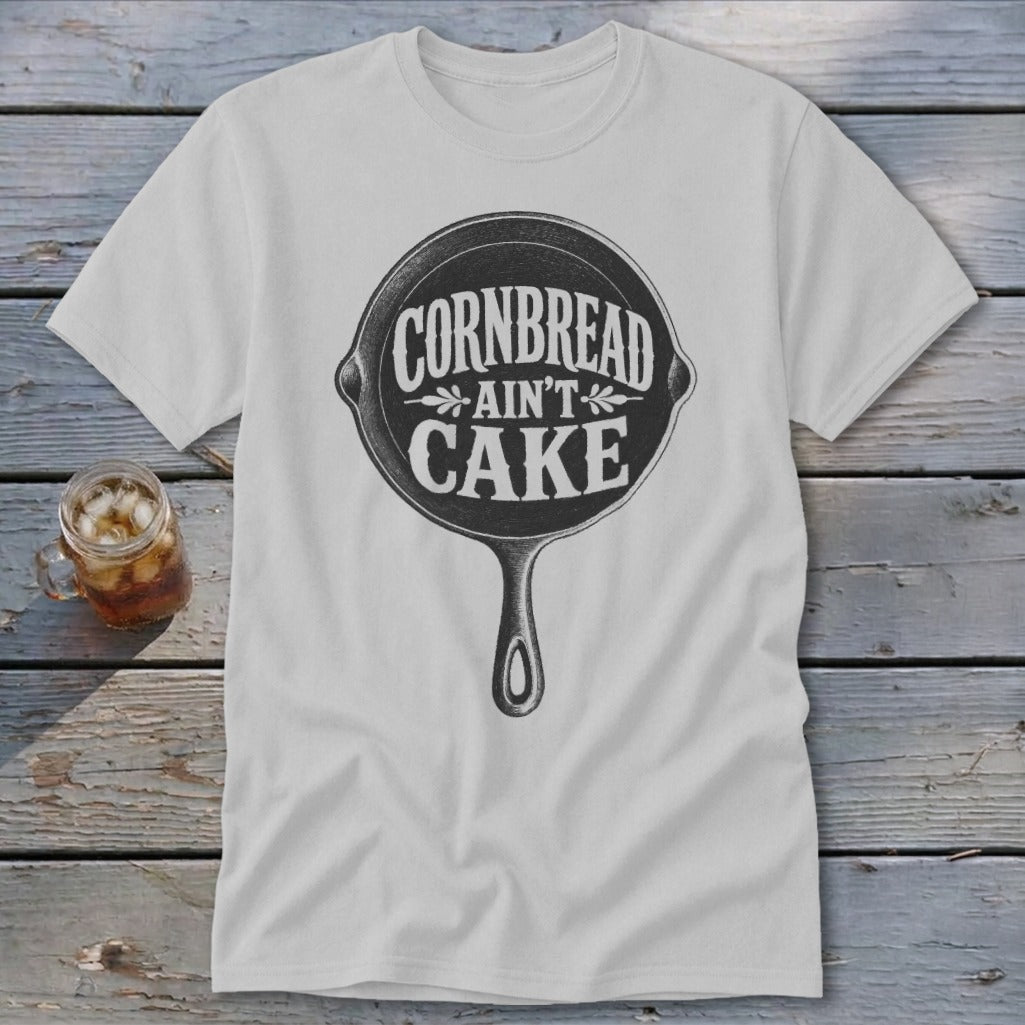 White t-shirt with "Cornbread Ain't Cake" text inside a cast iron skillet graphic.