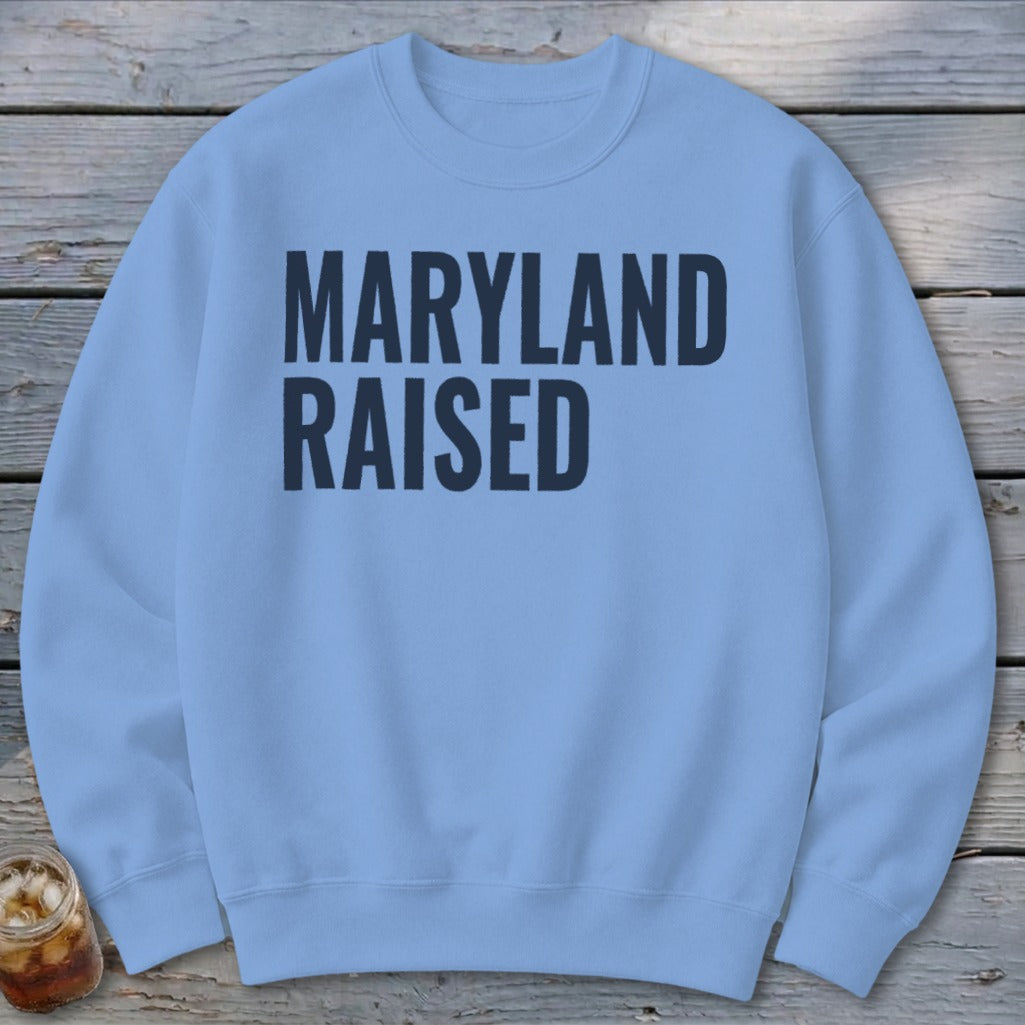 Light blue sweatshirt with dark blue text reading "MARYLAND RAISED".