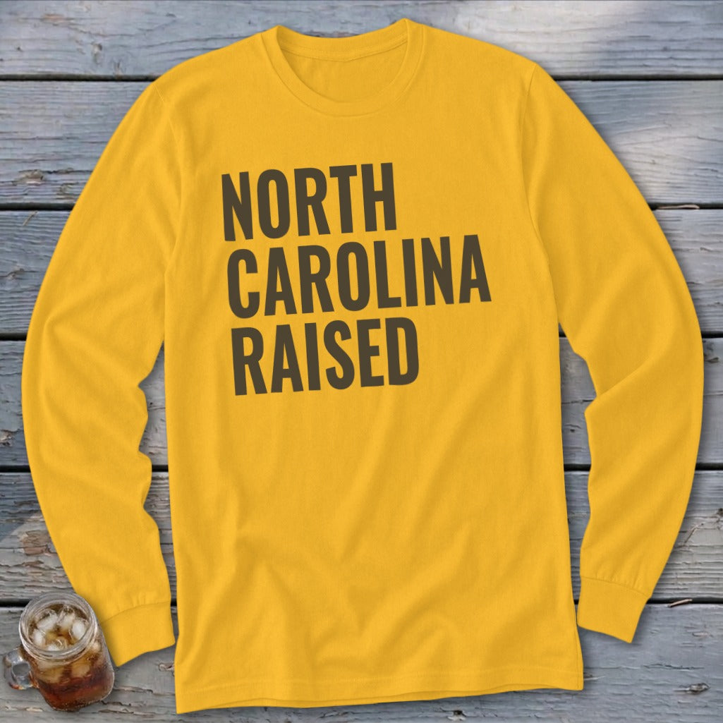 Yellow long sleeve shirt with "NORTH CAROLINA RAISED" text in dark grey.