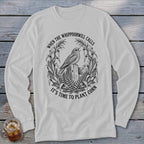 Light grey long-sleeve t-shirt with a black illustration of a bird and cornstalks, featuring the text WHEN THE WHIPPOORWILL CALLS IT'S TIME TO PLANT CORN.