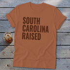 Brown t-shirt with "SOUTH CAROLINA RAISED" text and a glass of iced tea.