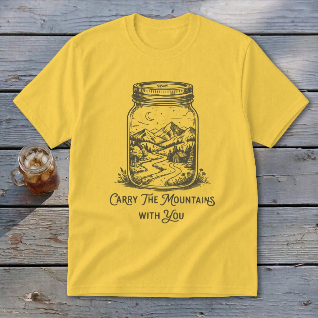 A yellow t-shirt featuring a mason jar graphic of a mountain landscape with the text Carry The Mountains With You.