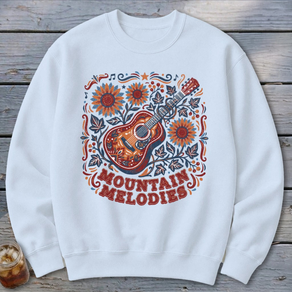 White crewneck sweatshirt with a guitar, sunflowers, and leaves design featuring the text "Mountain Melodies".