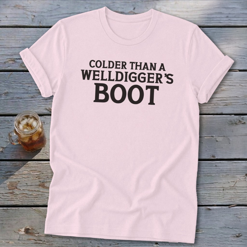 Pink t-shirt with "COLDER THAN A WELLDIGGER'S BOOT" printed in black.