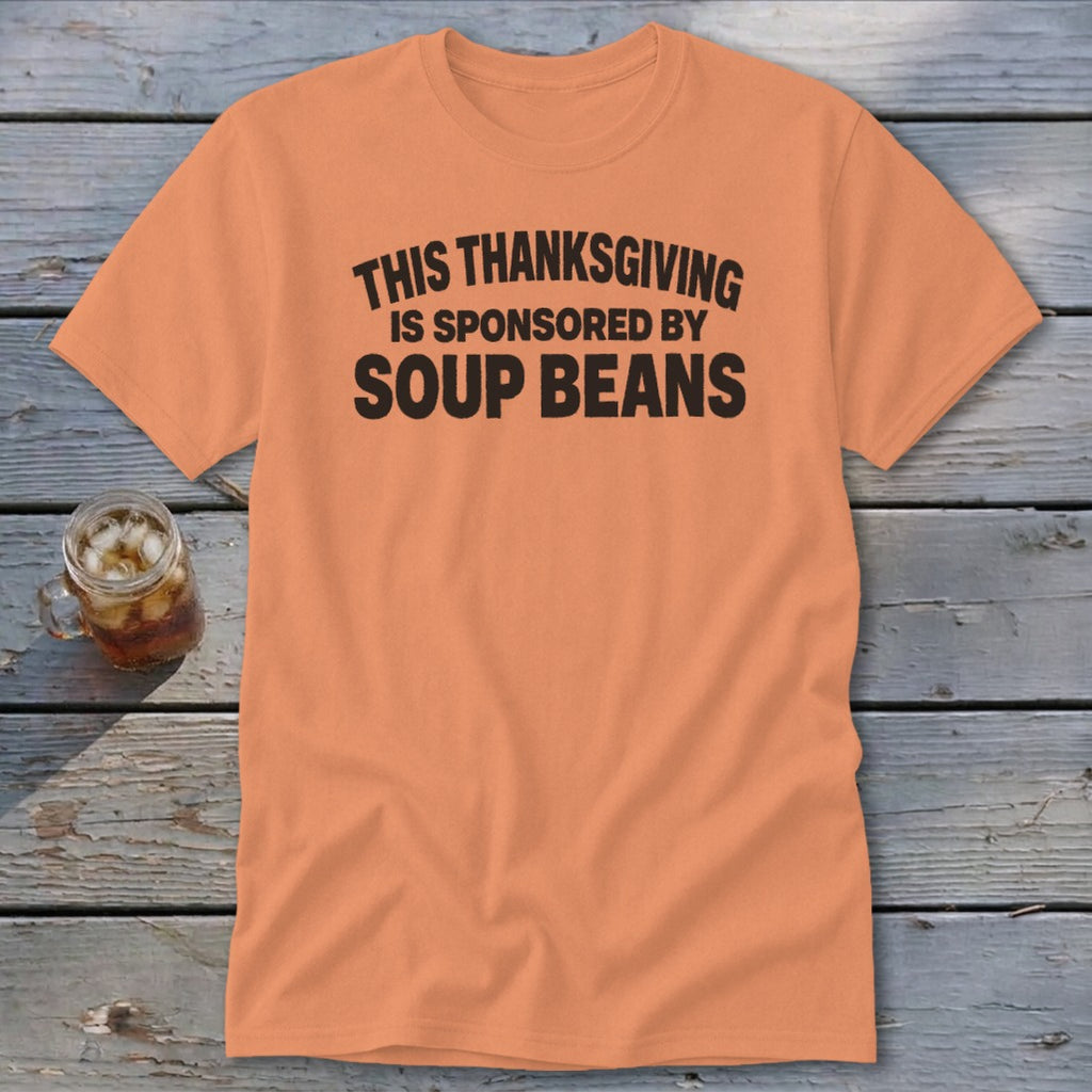 An orange t-shirt featuring the black text, "THIS THANKSGIVING IS SPONSORED BY SOUP BEANS."