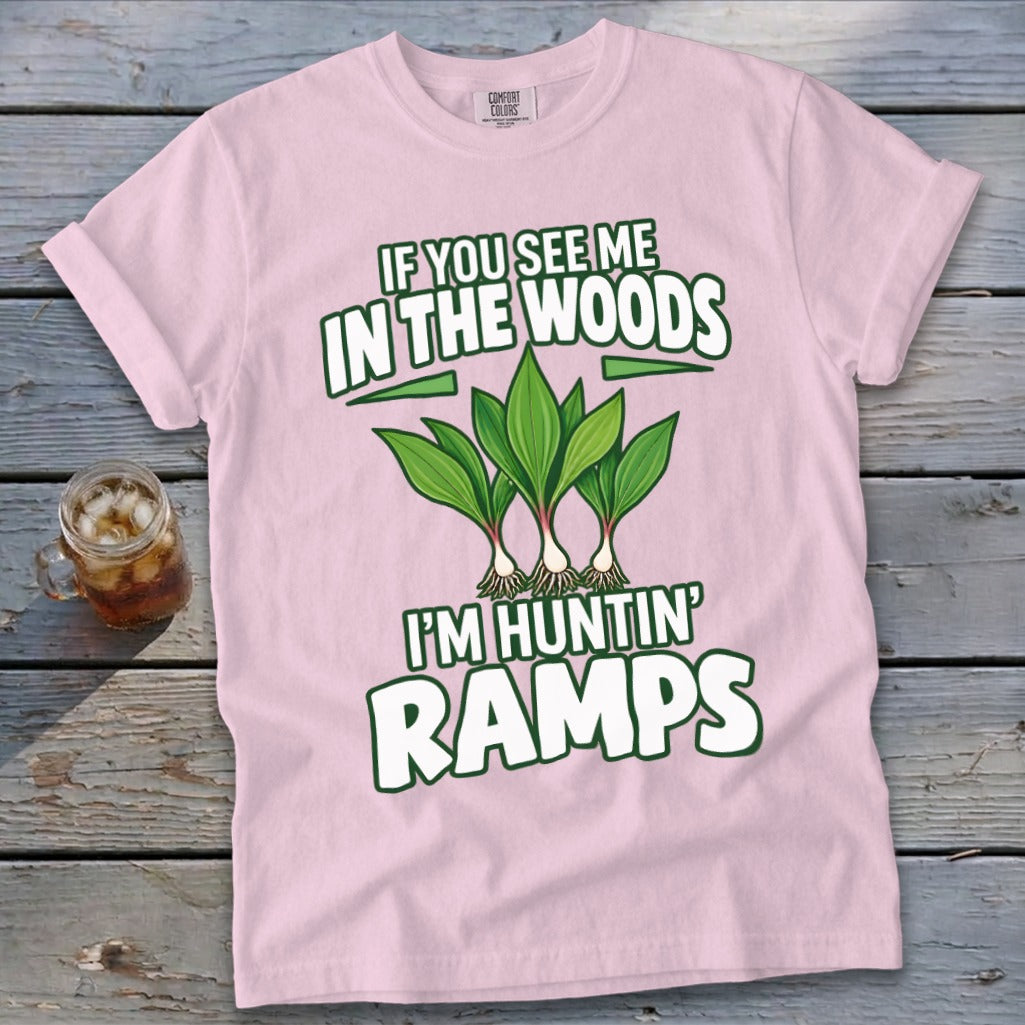 A light pink t-shirt featuring green text reading IF YOU SEE ME IN THE WOODS I'M HUNTIN RAMPS above an illustration of three ramp plants.
