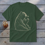 Green t-shirt with a drawing of a bear sitting and blowing on a dandelion.