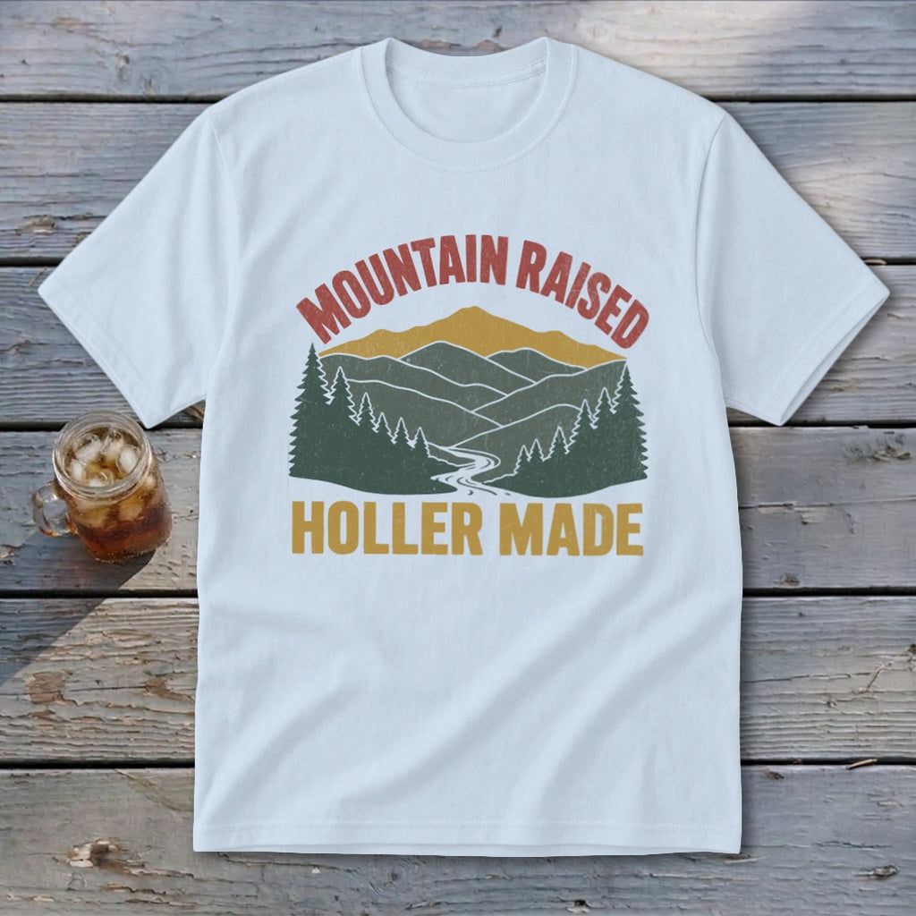 White t-shirt featuring a retro mountain graphic with the text Mountain Raised Holler Made.