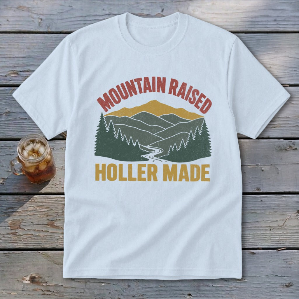 White t-shirt featuring a retro mountain graphic with the text Mountain Raised Holler Made.