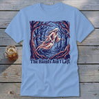 Light blue t-shirt with a ghost in a dark forest and text "The Haints Ain't Left."