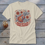 Beige t-shirt featuring a colorful graphic of a guitar, sunflowers, and the text Mountain Melodies.