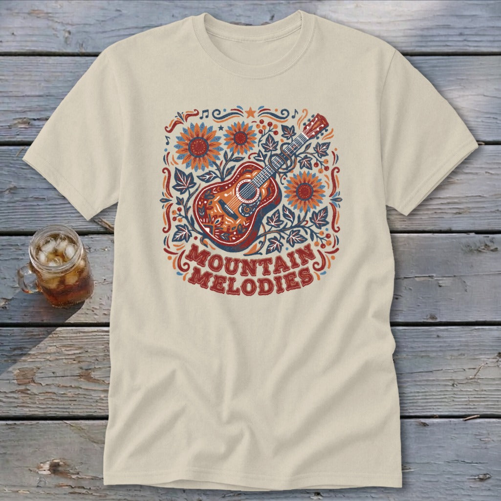 Beige t-shirt featuring a colorful graphic of a guitar, sunflowers, and the text Mountain Melodies.