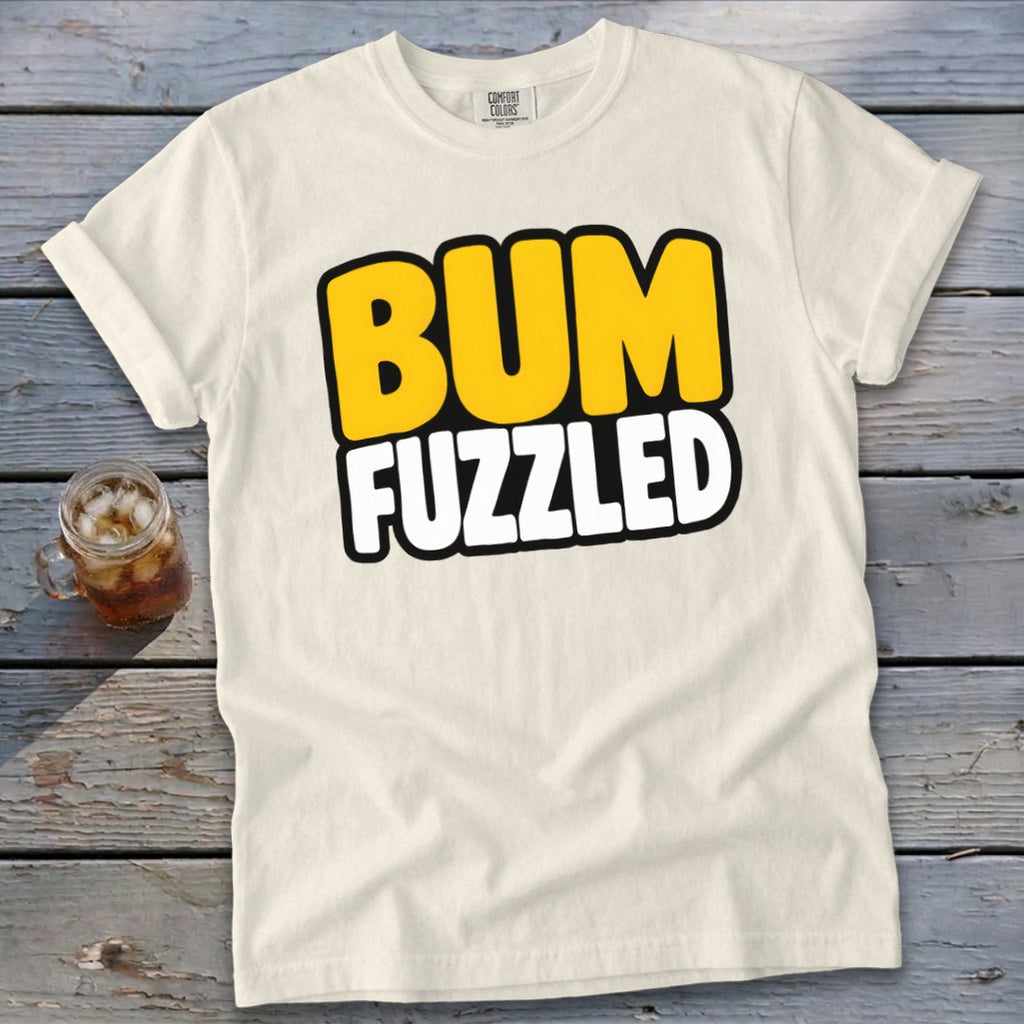 Off-white short-sleeve t-shirt with the words BUM FUZZLED printed in bold, yellow and white cartoon letters.