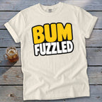 Off-white short-sleeve t-shirt with the words BUM FUZZLED printed in bold, yellow and white cartoon letters.