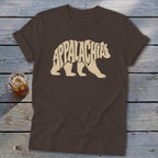 A brown short-sleeve t-shirt features a cream graphic of a walking bear filled with the word Appalachia.