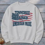 White sweatshirt with distressed American flag and text "TENNESSEE RAISED AMERICAN MADE".