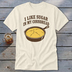 Cream t-shirt with text "I LIKE SUGAR IN MY CORNBREAD" and a cast iron skillet with cornbread.