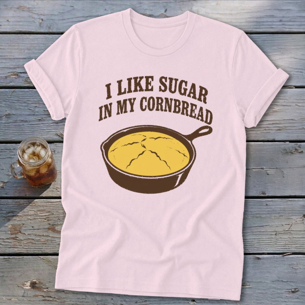 Pink t-shirt with brown text "I LIKE SUGAR IN MY CORNBREAD" and a cast iron skillet.