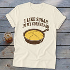 Cream t-shirt with "I like sugar in my cornbread" and a cast iron skillet of cornbread graphic.