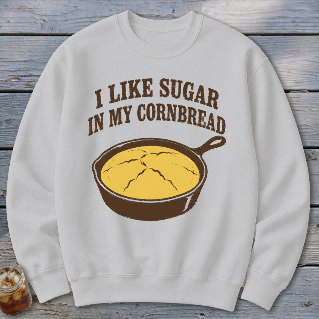 White sweatshirt with "I like sugar in my cornbread" text and a cast iron skillet of cornbread.