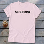 Pink t-shirt with black text "CREEKER" centered on the chest.