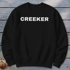 Black sweatshirt with white "CREEKER" text centered on the chest.