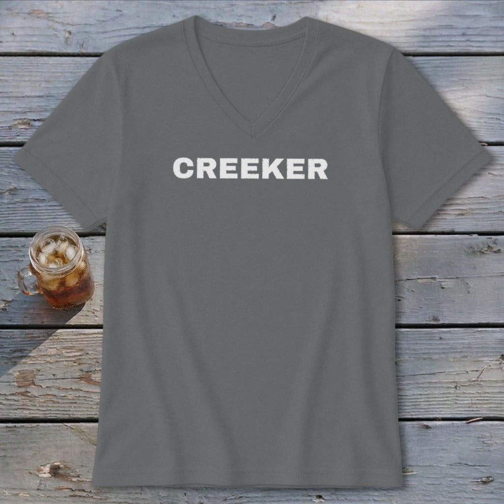 Gray v-neck t-shirt with white "CREEKER" text, next to a glass of iced tea.