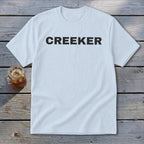 Light blue t-shirt with black text reading "CREEKER" and a glass of iced tea.