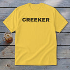 Yellow t-shirt with black text "CREEKER" and a glass of iced tea.