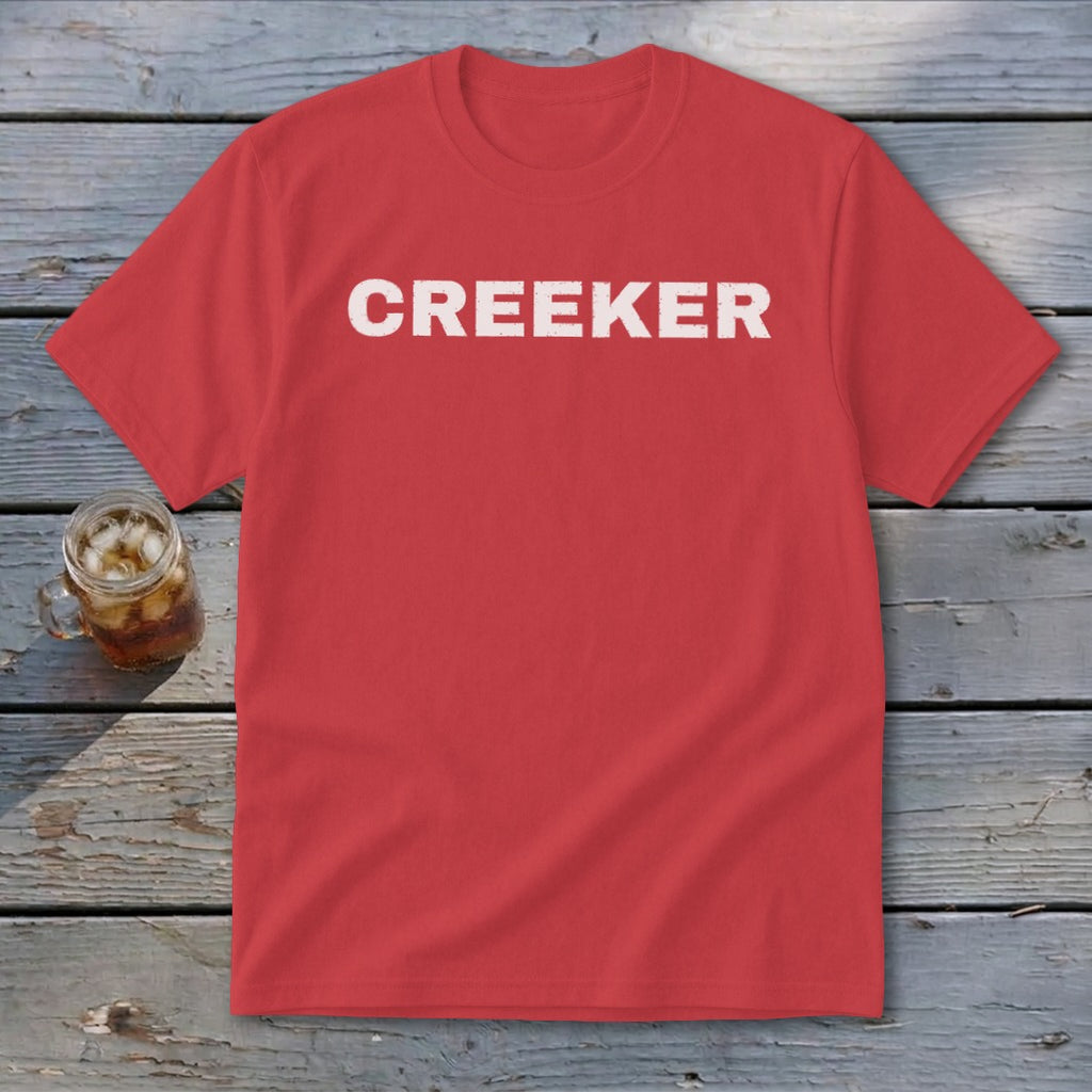 Red t-shirt with white distressed "CREEKER" text, next to a glass of iced tea.