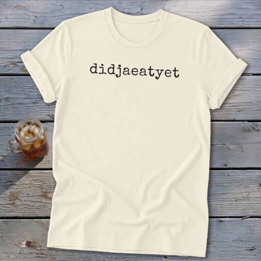 Cream t-shirt with "didjaeatyet" printed in black, next to a glass of iced tea.